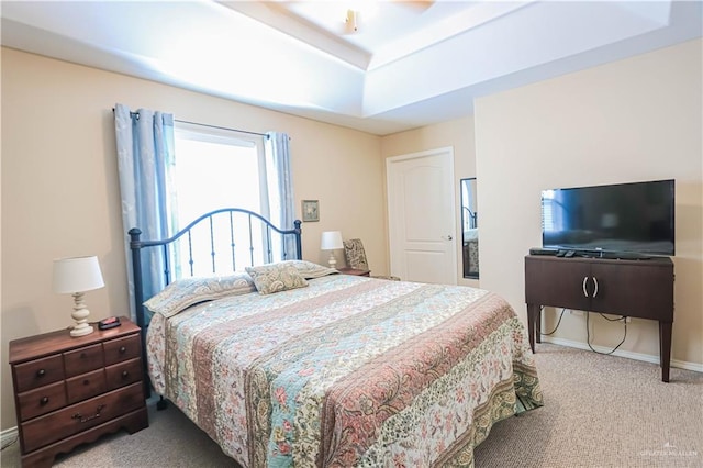 bedroom featuring carpet floors, a raised ceiling, and ceiling fan