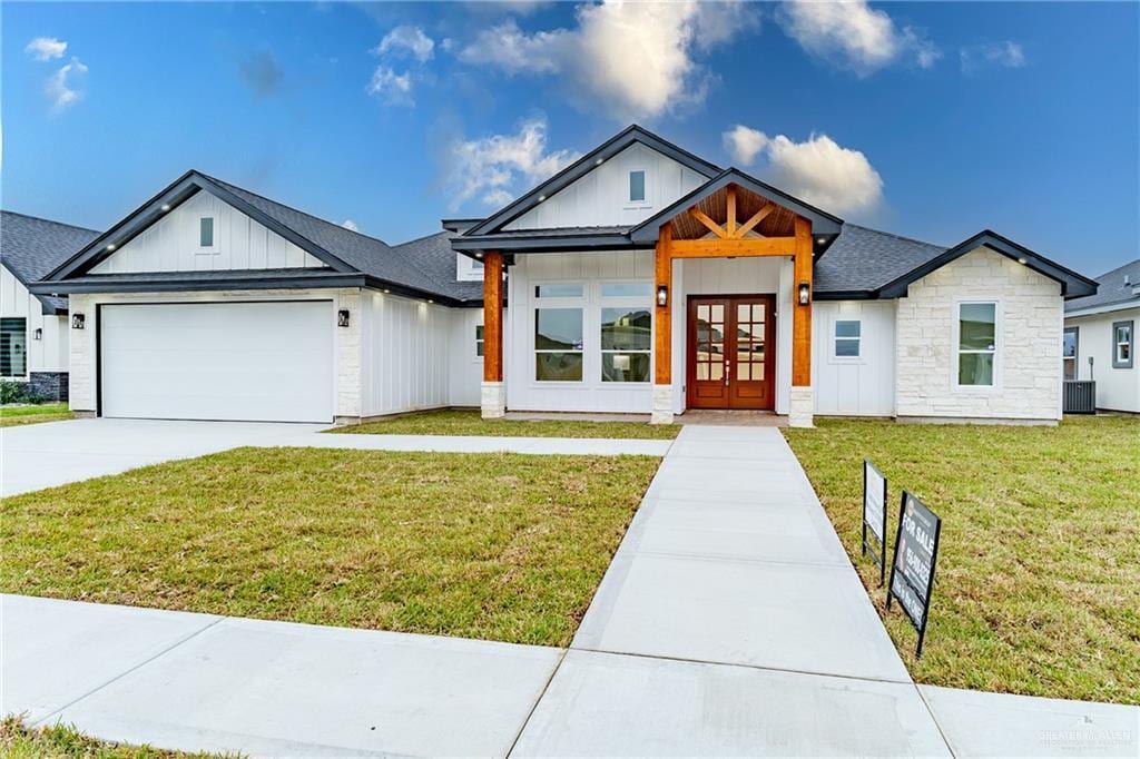 view of front of home featuring a front yard, french doors, and a garage