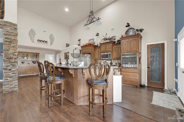 5213 Mile 8 1/2 Rd, Edinburg, TX 78541 - kitchen with high vaulted ceiling, stainless steel appliances, a kitchen bar, a spacious island, and brown cabinets