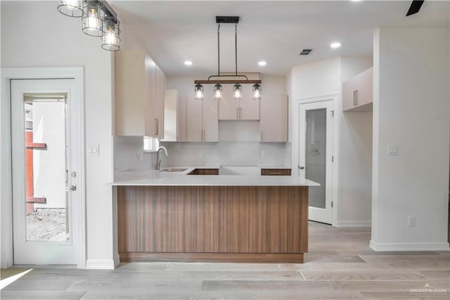 2310 Corales St, Mission, TX 78573 - kitchen featuring a peninsula, a sink, tasteful backsplash, light wood-style flooring, and recessed lighting