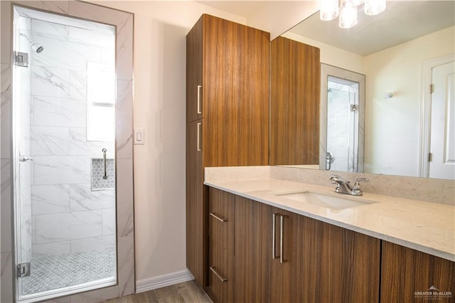 bathroom with wood-type flooring, vanity, and a shower with shower door