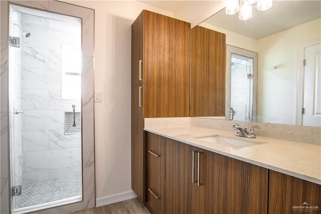 2310 Corales St, Mission, TX 78573 - full bath featuring a marble finish shower, vanity, baseboards, and wood finished floors