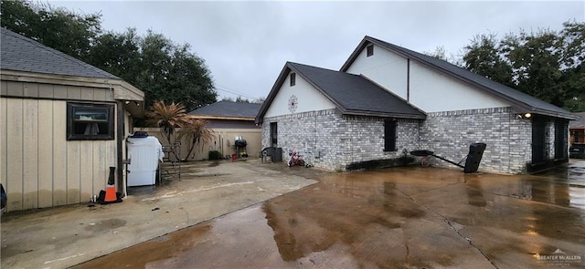 view of home's exterior with a patio area and brick siding