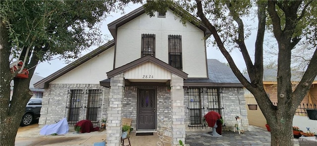 view of front of house featuring brick siding and stucco siding