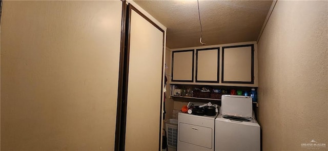 laundry area featuring cabinet space, a textured ceiling, washer and dryer, and a textured wall