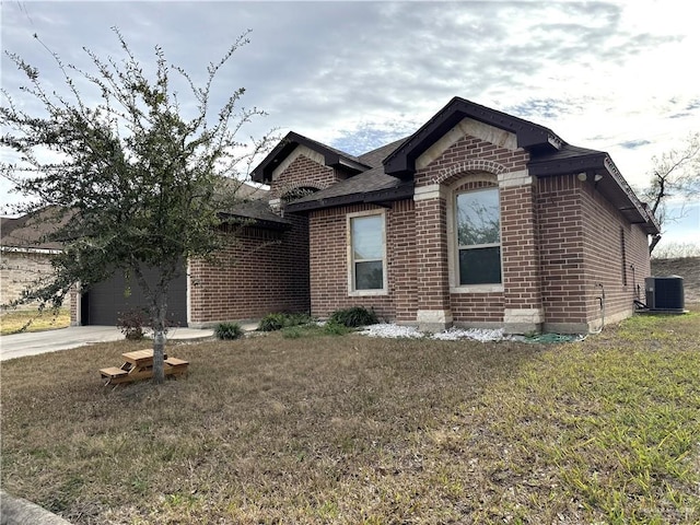 view of front of house featuring cooling unit, a garage, and a front yard