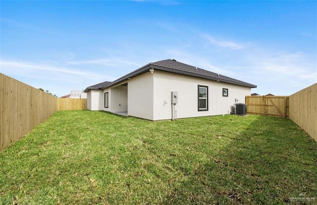 back of property featuring a lawn and central air condition unit