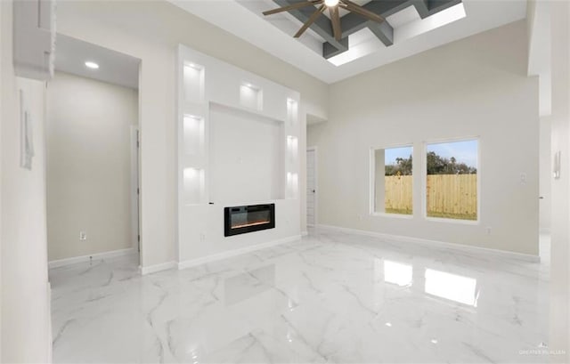 unfurnished living room featuring heating unit, ceiling fan, and a towering ceiling