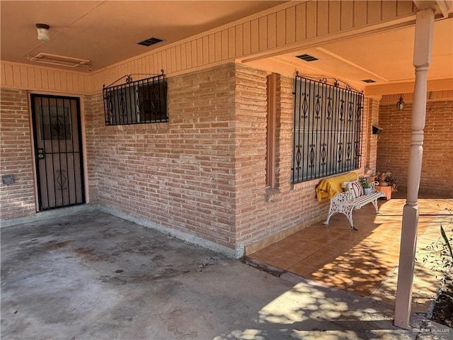 doorway to property with visible vents and brick siding