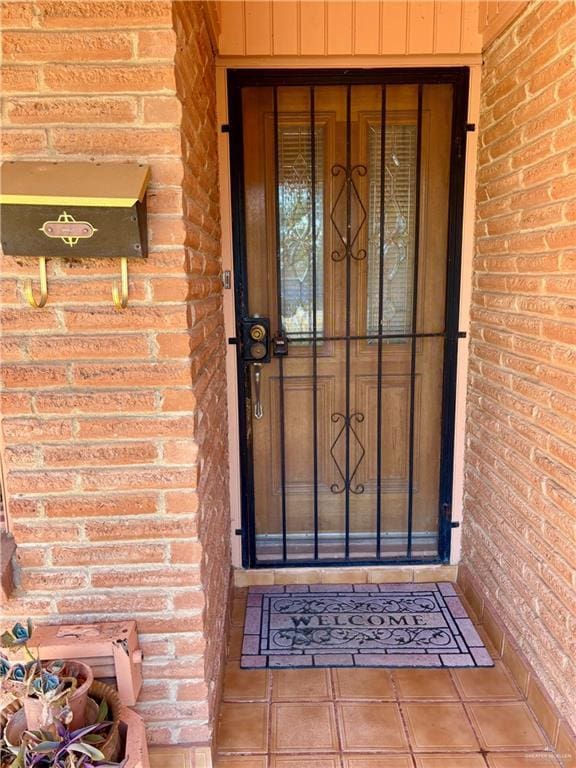 doorway to property with brick siding