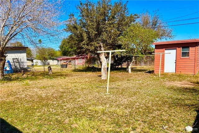 view of yard featuring a shed, fence, and an outdoor structure