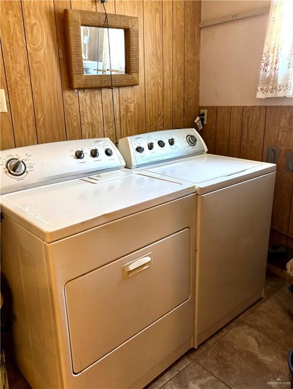 laundry area with laundry area, wooden walls, and separate washer and dryer