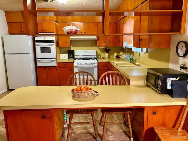 kitchen with white appliances, light countertops, and a warming drawer