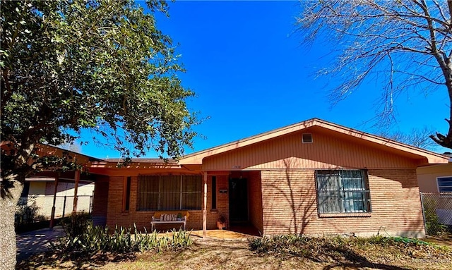 ranch-style home featuring fence and brick siding