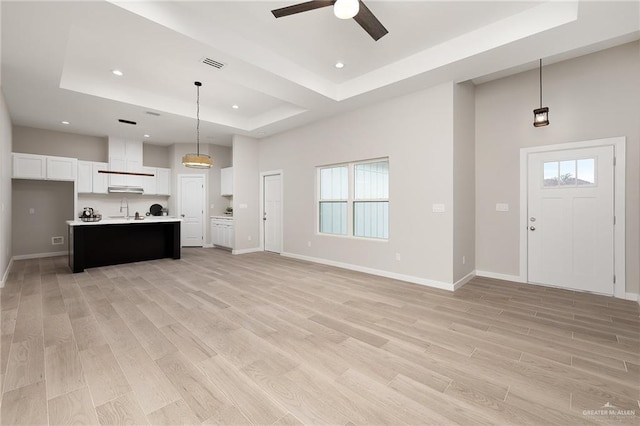 3513 E Adams Ave, Alton, TX 78573 - unfurnished living room with a raised ceiling, a sink, ceiling fan, light wood finished floors, and recessed lighting
