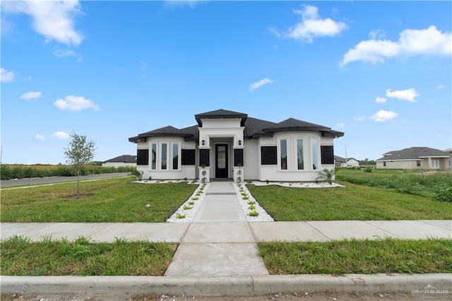 900 E 38th St, San Juan, TX 78589 - prairie-style house featuring a front lawn and stucco siding