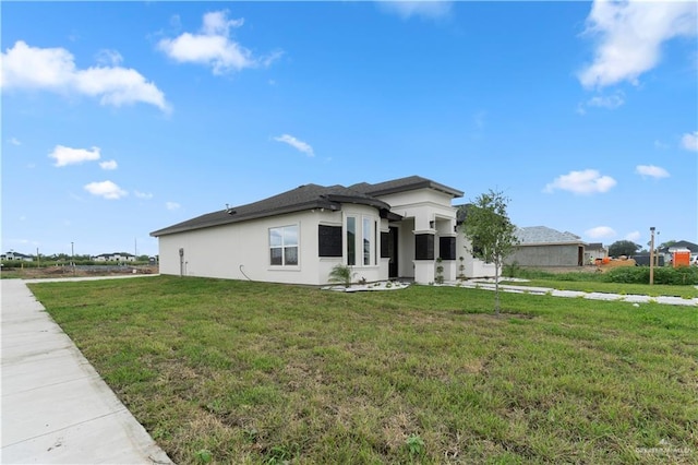 900 E 38th St, San Juan, TX 78589 - view of front of house with a front yard and stucco siding