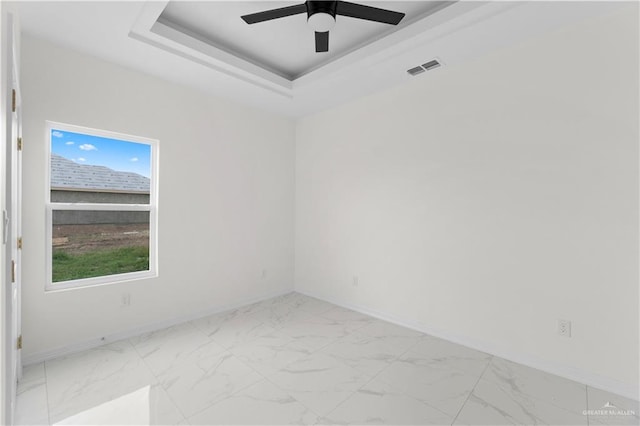 900 E 38th St, San Juan, TX 78589 - spare room featuring a ceiling fan, visible vents, baseboards, marble finish floor, and a tray ceiling