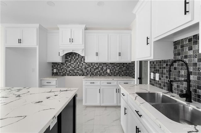 900 E 38th St, San Juan, TX 78589 - kitchen featuring white cabinetry, light stone counters, a sink, and marble finish floor