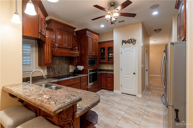 kitchen featuring a kitchen breakfast bar, sink, hanging light fixtures, kitchen peninsula, and stainless steel appliances