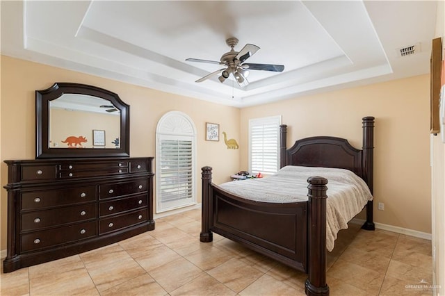 bedroom with ceiling fan and a raised ceiling