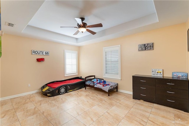 bedroom featuring a raised ceiling and ceiling fan