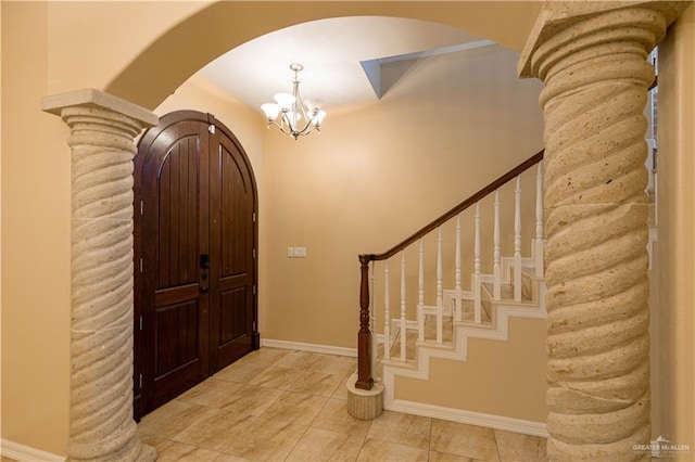 tiled entrance foyer featuring an inviting chandelier