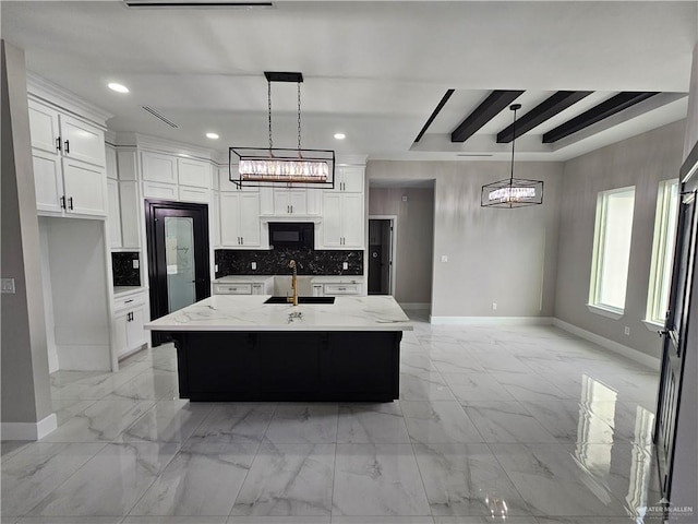 kitchen with black microwave, a sink, white cabinets, marble finish floor, and decorative backsplash