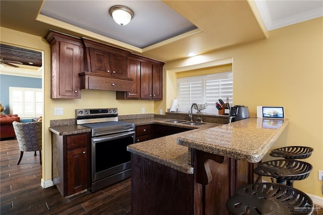 2729 Ashley Ct, Pharr, TX 78577 - kitchen featuring crown molding, a breakfast bar area, a raised ceiling, and stainless steel range with electric cooktop