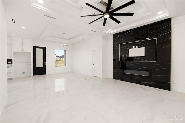 spare room with coffered ceiling, ceiling fan, and a tray ceiling