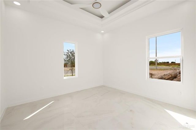 empty room with a tray ceiling and ceiling fan