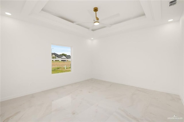 spare room featuring a tray ceiling and ceiling fan