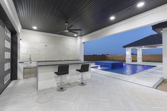 view of patio / terrace with an outdoor kitchen, sink, pool water feature, ceiling fan, and a fenced in pool