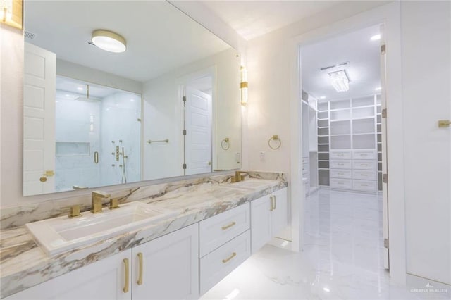 bathroom featuring a shower with door and vanity