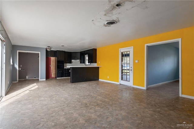 unfurnished living room with baseboards and visible vents