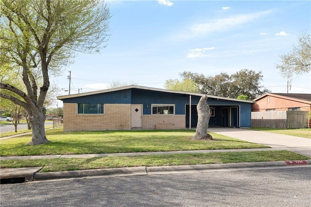 view of front of property featuring driveway, fence, a front yard, a carport, and brick siding