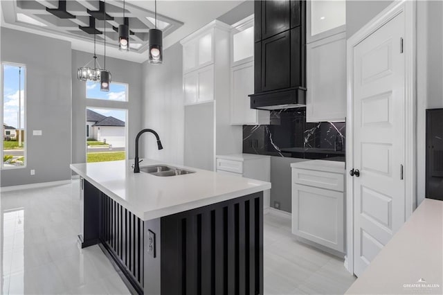 537 Kiwi St, Edinburg, TX 78541 - kitchen featuring coffered ceiling, a sink, backsplash, a center island with sink, and glass insert cabinets