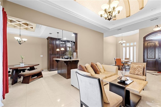 living room with light tile patterned flooring, an inviting chandelier, and a tray ceiling