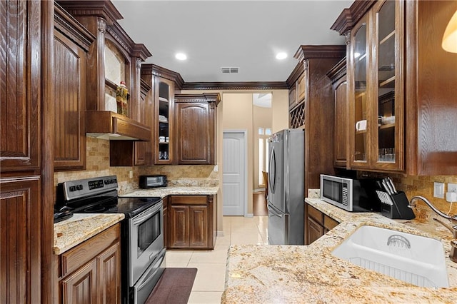 kitchen with light tile patterned floors, appliances with stainless steel finishes, sink, and backsplash