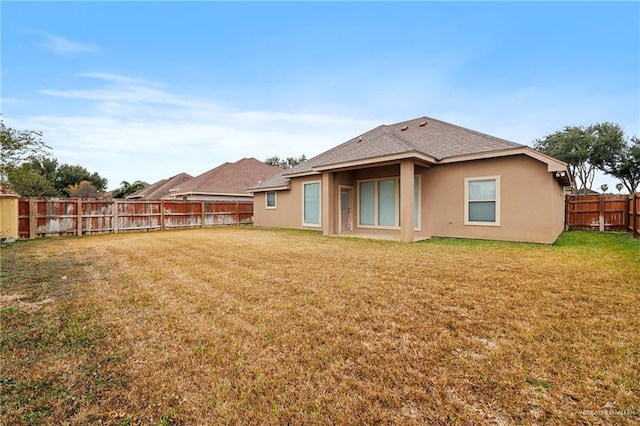 rear view of house featuring a lawn