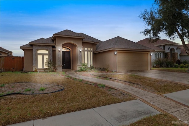 prairie-style house with a garage and a front lawn