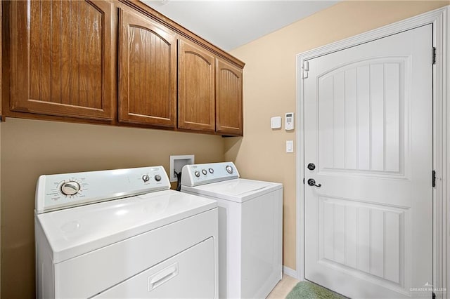 washroom featuring washer and clothes dryer and cabinets