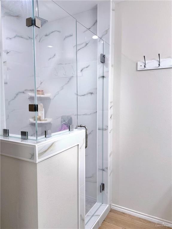 bathroom featuring hardwood / wood-style flooring and walk in shower