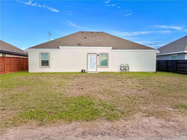 rear view of property featuring a lawn