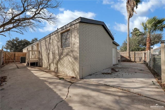 view of side of property with central AC unit and a patio