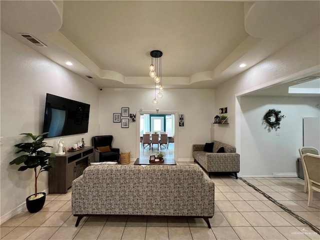 living room with light tile patterned flooring and a raised ceiling