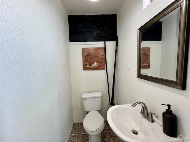 bathroom featuring toilet, tile patterned flooring, and sink