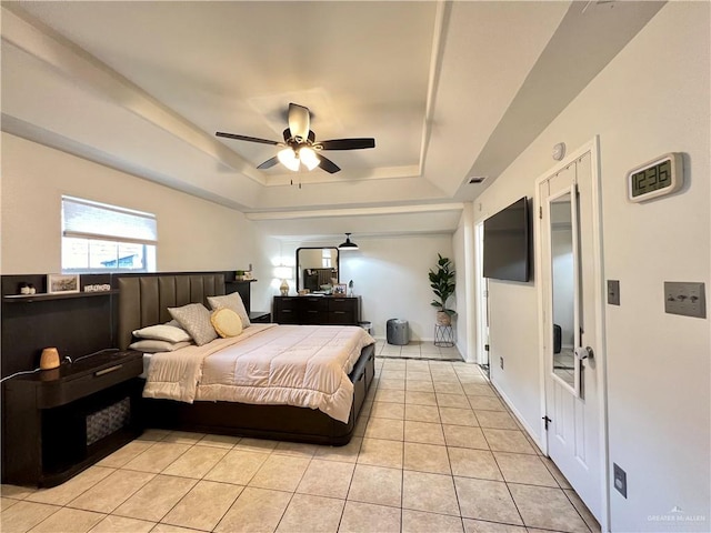 bedroom with a tray ceiling, ceiling fan, and light tile patterned flooring