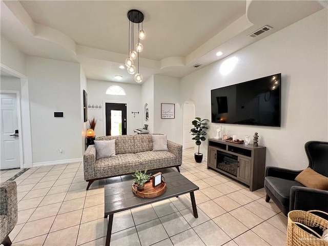 living room with light tile patterned floors and a tray ceiling