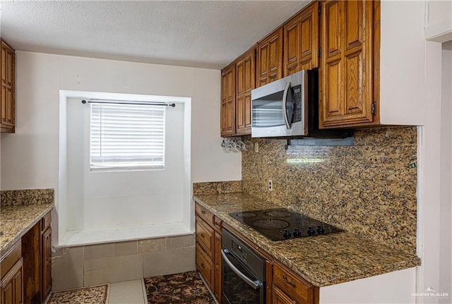 3300 N 20th St, Mcallen, TX 78501 - kitchen featuring oven, stainless steel microwave, black electric cooktop, decorative backsplash, and dark stone counters